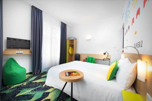 a hotel room with a bed and a table at Ibis Styles Budapest Center in Budapest