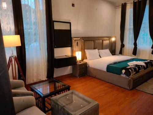Un dormitorio con una cama, un televisor y un sofá. en The Blossom Glee, en Bhimtal