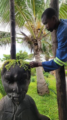 a man standing next to a skull statue at Tofo Beach Gardens in Inhambane