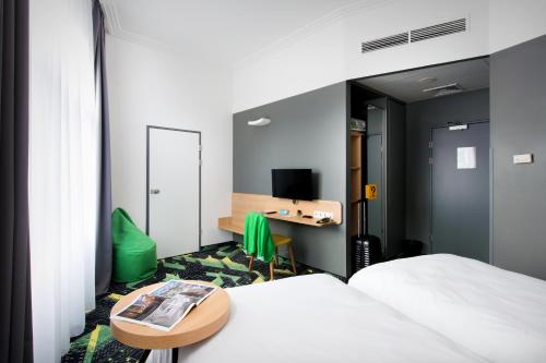a hotel room with a bed and a table and a desk at Ibis Styles Budapest Center in Budapest