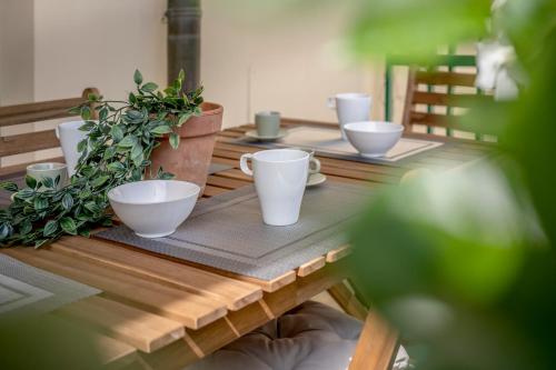 a wooden table with cups and plants on it at Modern Beach Apartment Near Forte dei Marmi in Marina di Massa