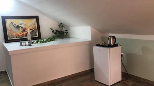 a room with a white refrigerator and a picture at Oriente Sole in Dhërmi