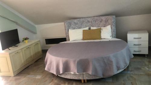 a bedroom with a large bed and a tv at Oriente Sole in Dhërmi