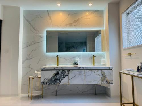 a bathroom with a sink and a mirror at Luxury Hills 1500ｍ2超絶景パティオ サウナ BBQ 駐車場4台 プール ペット 空港そば in Fukuoka