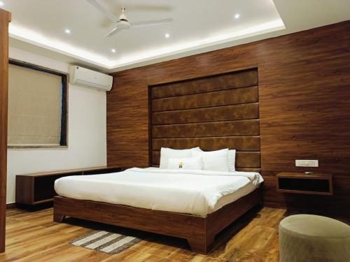 a bedroom with a large bed with a wooden headboard at Triton Suites By Bestinn Leisure in Bengaluru
