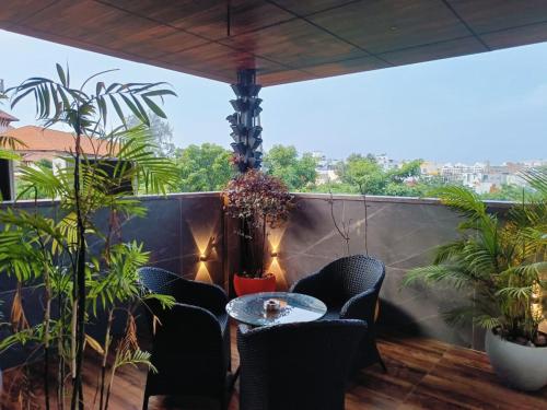 a balcony with a table and chairs and plants at Triton Suites By Bestinn Leisure in Bengaluru