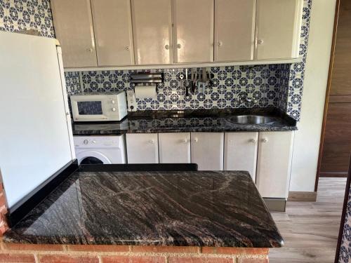 a kitchen with a counter top and a microwave at LA CASUCA planta baja COMILLAS in Comillas