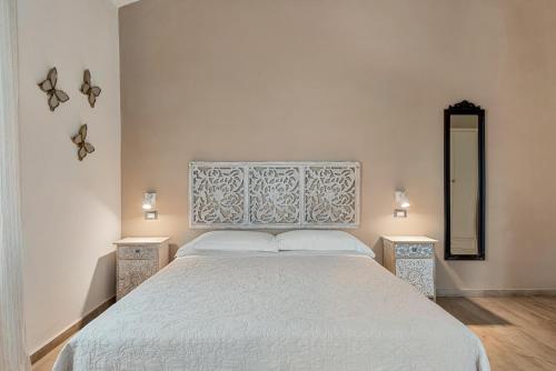 a bedroom with a white bed with two night stands at VISTALAGO VERSILIA in Massarosa