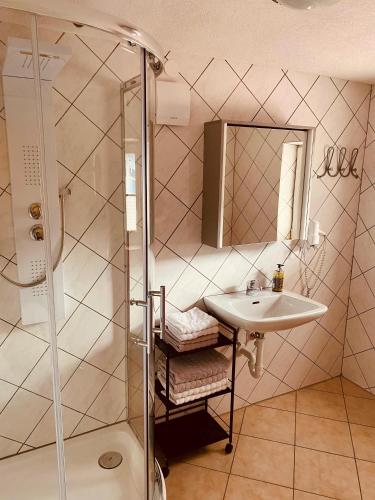 a bathroom with a sink and a shower at Gästehaus Hoamat'l in Bach