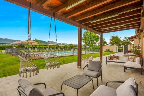 an outdoor patio with chairs and a swing at VISTALAGO VERSILIA in Massarosa