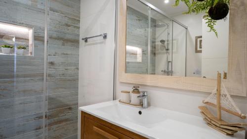 a bathroom with a sink and a glass shower at Luxury Beach House Apartment - Golf & Tennis Court & Pool View in Albufeira