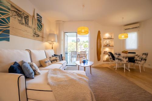 a living room with a white couch and a table at Luxury Beach House Apartment - Golf & Tennis Court & Pool View in Albufeira