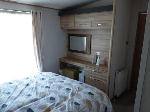 a bedroom with a bed and a tv on a wall at Atlantic View in Ferryside