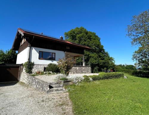 a white house with a window and a yard at Ferienhaus Westerbuchberg in Übersee