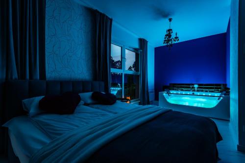 a blue bedroom with a bed and a tub at APARTAMENTY MIERZEJA - Apartament Zmysłów z prywatnym Jacuzzi tylko dla Dorosłych, 500 m od plaży, Stegna Park II, bezpłatny meleks in Stegna