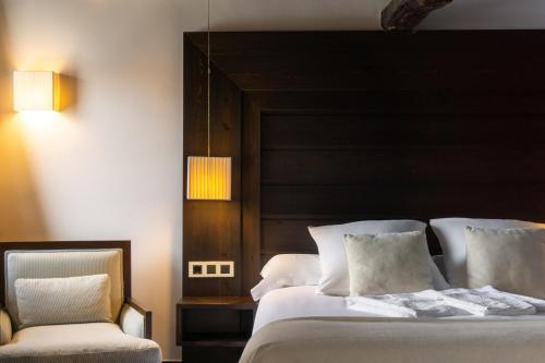 a bedroom with a large bed and a chair at La Plaza in Hervás
