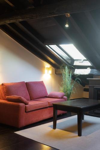 a living room with a red couch and a table at La Plaza in Hervás