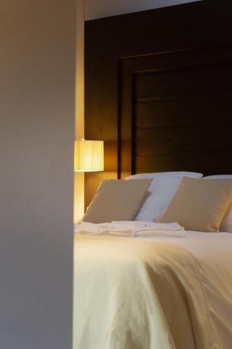 a bedroom with a white bed with a headboard at La Plaza in Hervás