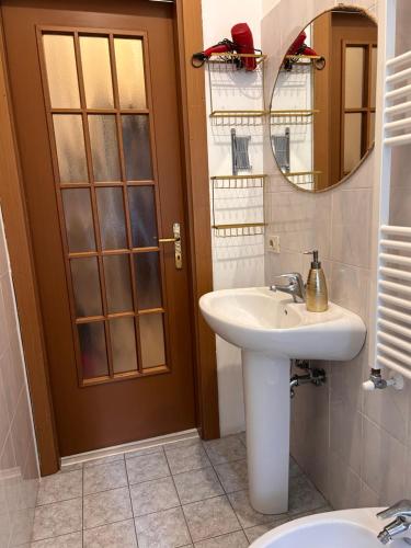 a bathroom with a sink and a mirror and a toilet at Claudia's Home in FieraCity&MiCo&SanSiro in Milan