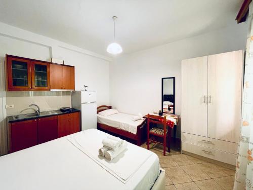 a small room with two beds and a kitchen at Guesthouse Dollomaja Ksamil in Ksamil