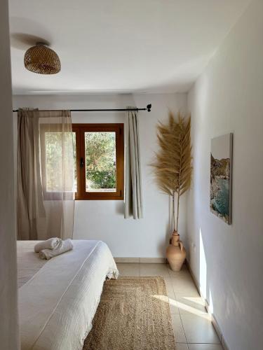 a white bedroom with a bed and a window at Agroturismo Sa Marina - Adults Only in Cala Boix