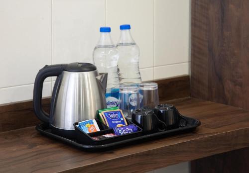 a tray with a coffee maker on a counter with bottles of water at Victory Stay in Chennai