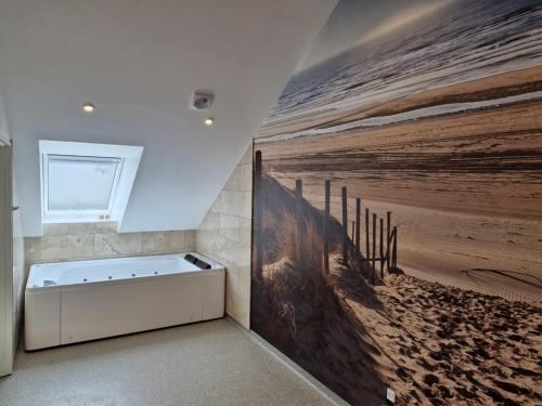a bathroom with a large painting of the beach at Gørdinglund Herregård Bed & Breakfast in Gørding