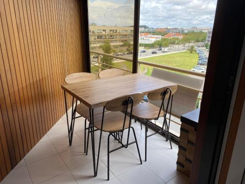 a table and chairs on a balcony with a window at Tertúlias com as ondas, T2 in Vila do Conde