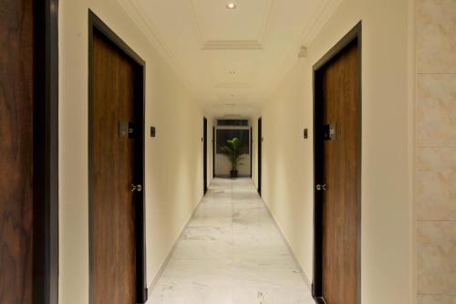 a hallway with wooden doors and a plant in the distance at Victory Stay in Chennai