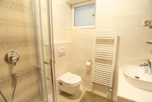 a small bathroom with a toilet and a sink at Villa Marija in Baška