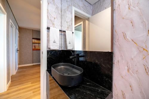 a bathroom with a black sink and a mirror at Riviera Luxo Frente Mar 2 Suítes by Achei Camboriú in Cabeçudas