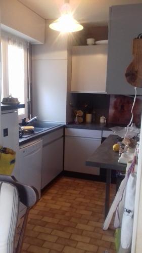 une cuisine avec un évier et une table à l'intérieur dans l'établissement Vue mer exceptionnelle, à Cabourg