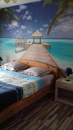 - une chambre avec un lit et une peinture sur l'océan dans l'établissement Vue mer exceptionnelle, à Cabourg