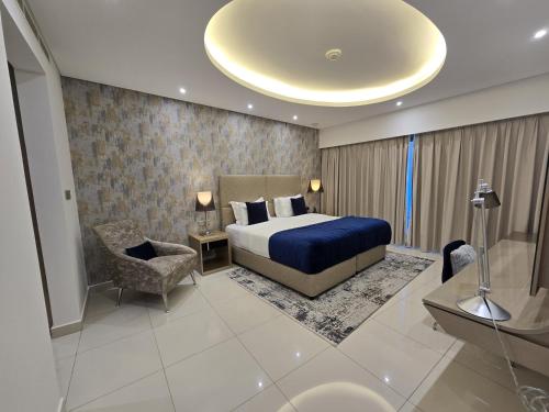 a hotel room with a bed and a chair at Quill Residence at Paramount Towers 3 BR Creek View in Dubai