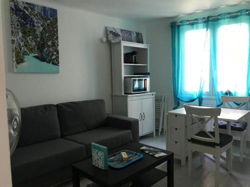 un salon avec un canapé et une table dans l'établissement Le Rouge-Gorge, à Gréoux-les-Bains