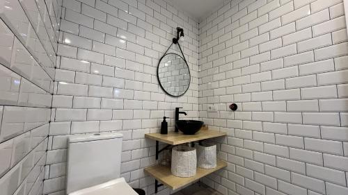 a white bathroom with a sink and a mirror at Ohana Raiz Casa con Patio Parking Gratuito y Exclusivo in Merida