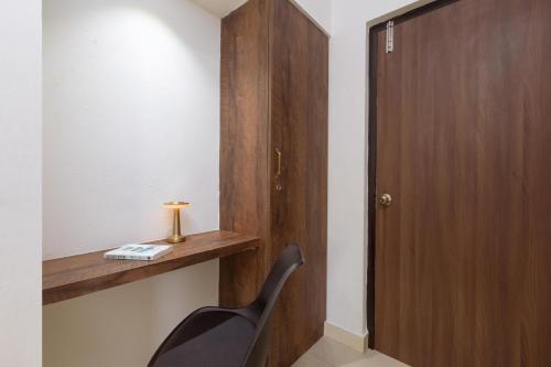 a black chair sitting next to a wooden door at Victory Stay in Chennai
