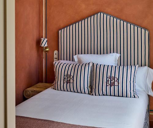 a bedroom with a large bed with striped pillows at Cristine Bedfor Málaga in Málaga