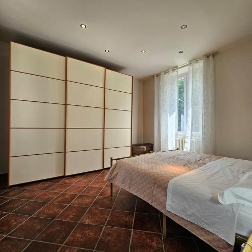 a bedroom with a large bed and a window at Il Girasole Holiday Home in Porto Ceresio