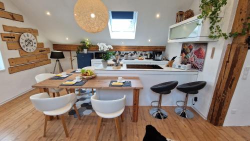 a kitchen and dining room with a wooden table and chairs at FeWo Familie Thoma in Argenbühl