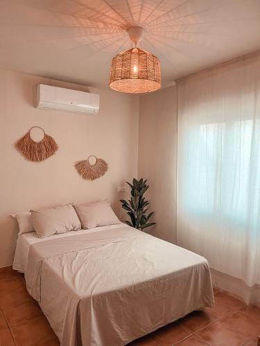 a bedroom with a white bed and a fan at Rooftop 24 in Calpe