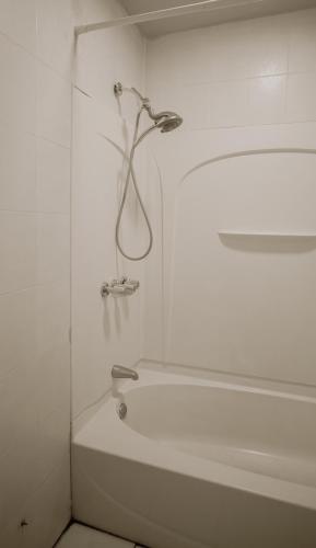 a white bathroom with a bath tub and a shower at Private room with Shared bath on Union Square 11 in New York