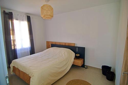 une chambre avec un lit et une fenêtre dans l'établissement Charmante maison de ville avec jardin, à Montélimar