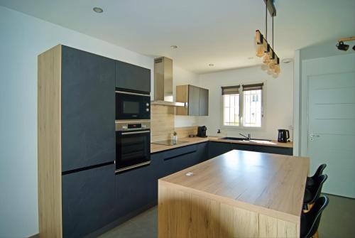 - une cuisine avec une table en bois et un comptoir dans l'établissement Charmante maison de ville avec jardin, à Montélimar