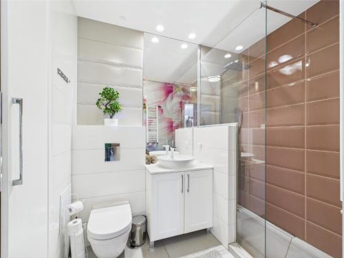 een witte badkamer met een toilet en een wastafel bij ApartamentySnu, Słoneczny Glam z parkingiem, Centrum in Radom