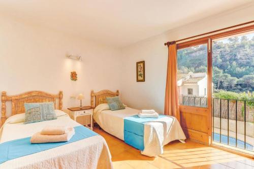 a bedroom with two beds and a balcony at Villa Can March by Villa Plus in Cala de Sant Vicenc