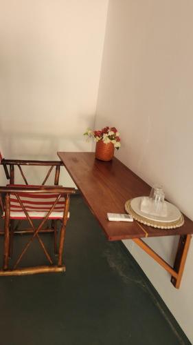 a wooden table with a chair and a plate on it at Tofo Beach Gardens in Inhambane
