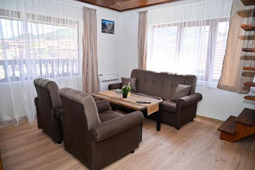 a living room with two chairs and a table at Къща Джано in Dobrinishte