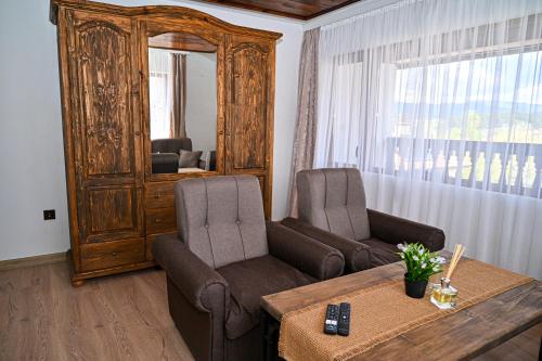 a living room with two chairs and a table and a mirror at Къща Джано in Dobrinishte