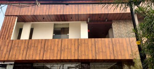 an external view of a house with a wooden deck at Madhusudan Farms in Govardhan